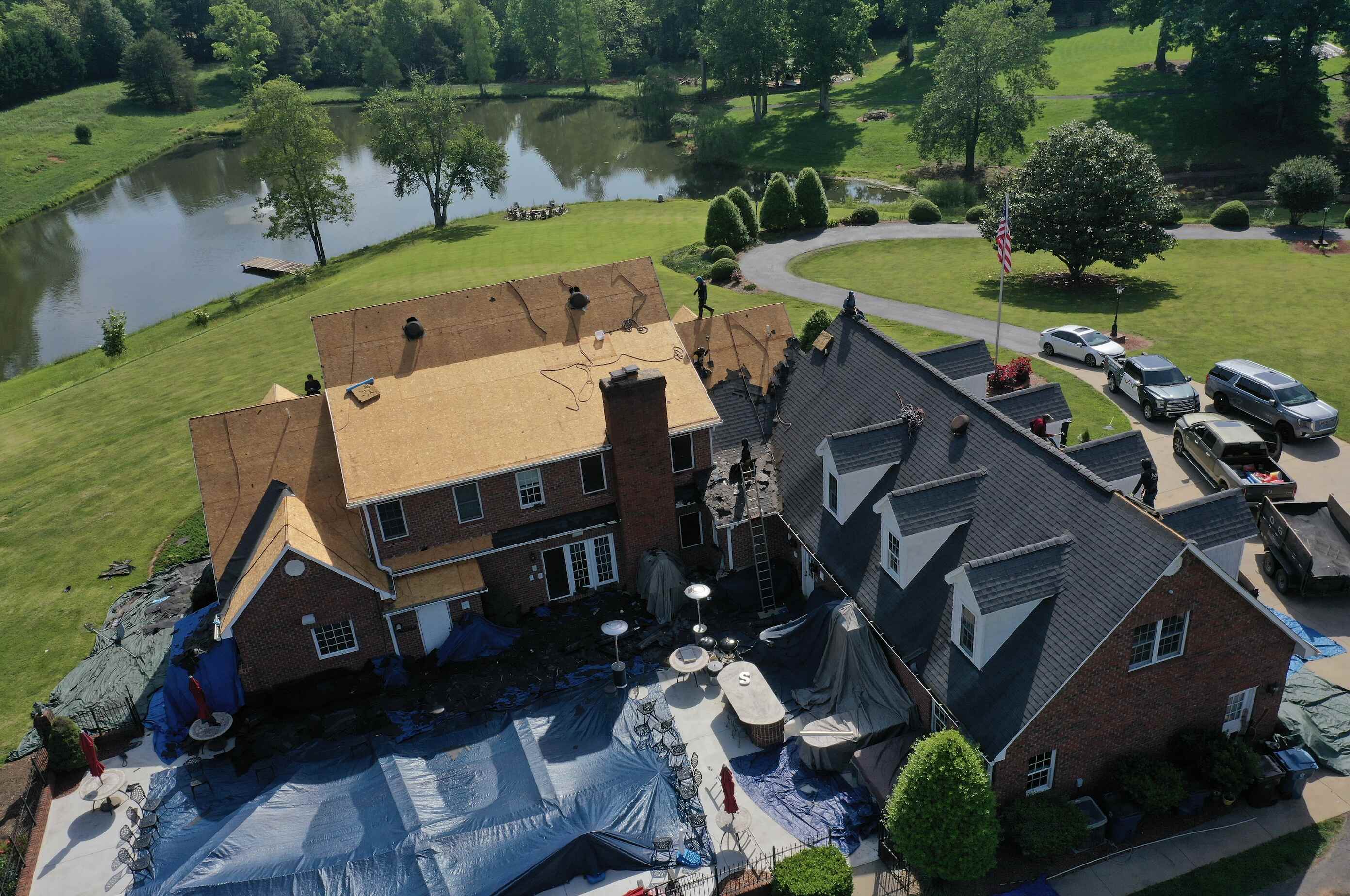 Rear angle showing old asphalt shingles being removed from a farmhouse roof in Hickory NC by Catawba Valley Roofing