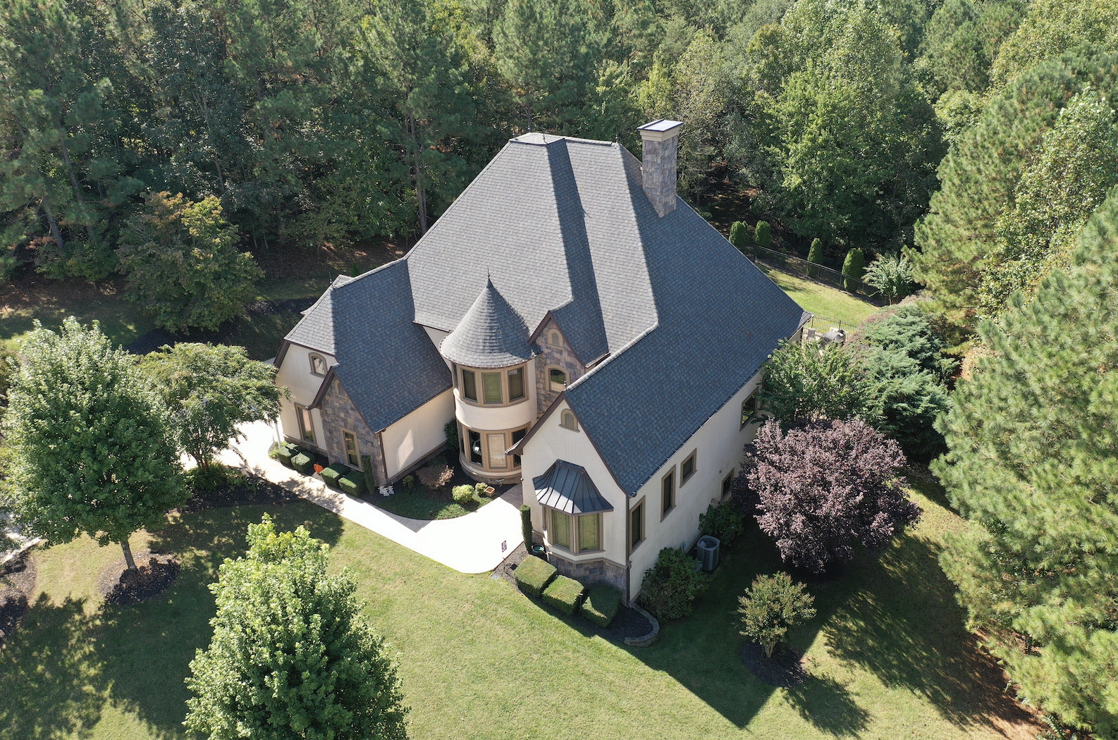 Aerial view of a large house with a new roof surrounded by trees in Hickory NC