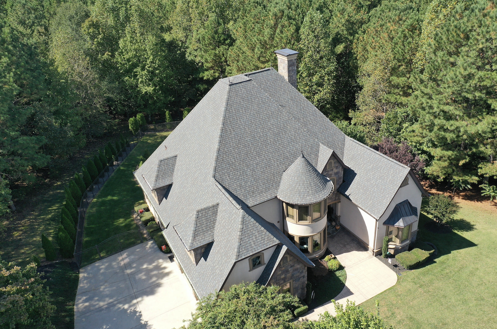 Aerial view of a two-story house with a new roof and chimney, surrounded by trees in Hickory NC