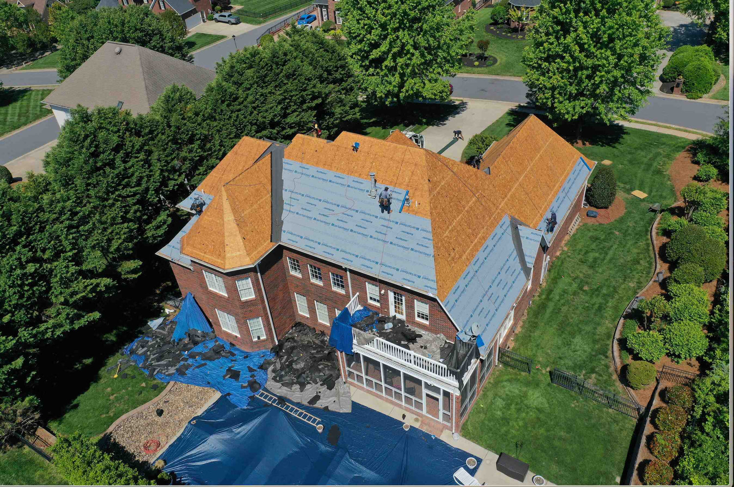 Roofers removing old shingles during residential roof replacement in Hickory NC